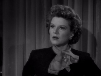 Movie still from “Raw Deal” (1948), directed by Anthony Mann – An old photo of an older woman in a black suit; Close Up shot, Low angle