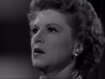 Movie still from “Raw Deal” (1948), directed by Anthony Mann – An old photo of an old woman with a sad look on her face; Close Up shot, Low angle