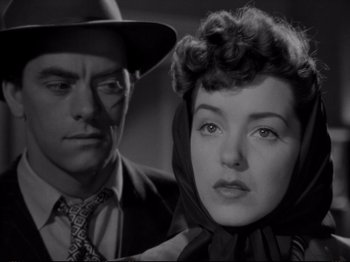 Movie still from “Raw Deal” (1948), directed by Anthony Mann – A man and a woman standing next to each other; Close Up shot, Low angle