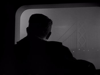 Movie still from “Raw Deal” (1948), directed by Anthony Mann – A man sitting on a train looking out the window; Medium shot, Low angle