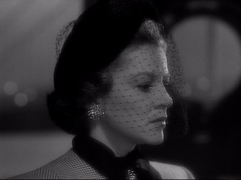 Movie still from “Raw Deal” (1948), directed by Anthony Mann – A black and white photo of a woman wearing a veil; Close Up shot, Over the shoulder angle