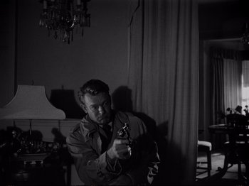 A black and white photo of a man holding a camera