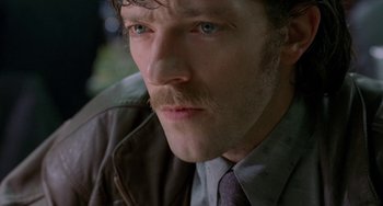 Movie still from “Read My Lips” (2001), directed by Jacques Audiard – A person wearing a suit and tie; Close Up shot, High angle