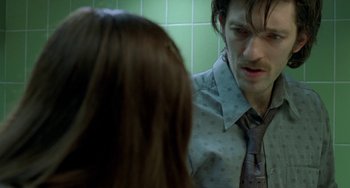 Movie still from “Read My Lips” (2001), directed by Jacques Audiard – A man and a woman are looking at each other in the mirror; Close Up shot, Over the shoulder angle