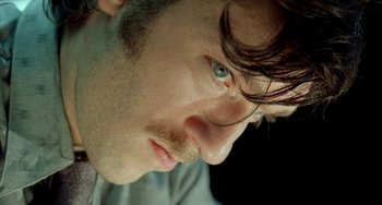 Movie still from “Read My Lips” (2001), directed by Jacques Audiard – A man's face with green eyes; Extreme Close Up shot, High angle