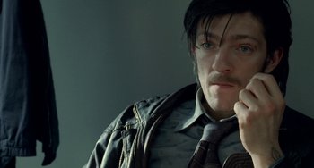 Movie still from “Read My Lips” (2001), directed by Jacques Audiard – A man in a tie and a leather jacket is talking on the phone; Close Up shot, High angle