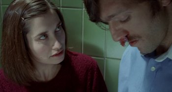 Movie still from “Read My Lips” (2001), directed by Jacques Audiard – A woman and a man standing next to each other in front of a tiled wall; Close Up shot, Over the shoulder angle