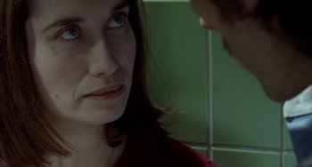 Movie still from “Read My Lips” (2001), directed by Jacques Audiard – A woman looking at another woman in a green room; Close Up shot, Over the shoulder angle