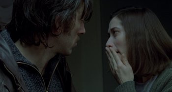 Movie still from “Read My Lips” (2001), directed by Jacques Audiard – A man and a woman face to face in front of a wall; Close Up shot, Low angle