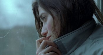 Movie still from “Read My Lips” (2001), directed by Jacques Audiard – A person looking out a window; Close Up shot, Over the shoulder angle