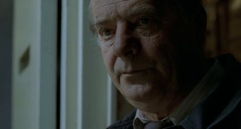 Movie still from “Read My Lips” (2001), directed by Jacques Audiard – An older man looking out of a window; Close Up shot, Low angle