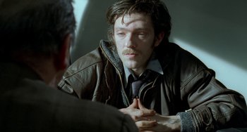 Movie still from “Read My Lips” (2001), directed by Jacques Audiard – A man sitting in front of another man in front of a mirror; Close Up shot, Over the shoulder angle
