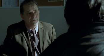 Movie still from “Read My Lips” (2001), directed by Jacques Audiard – A man in a suit and tie talking to a woman; Close Up shot, Over the shoulder angle