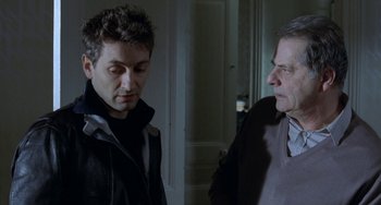 Movie still from “Read My Lips” (2001), directed by Jacques Audiard – Two men standing next to each other in a room; Close Up shot, Over the shoulder angle