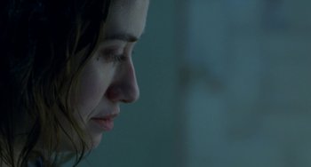 Movie still from “Read My Lips” (2001), directed by Jacques Audiard – A woman's face in a dark room; Close Up shot, Over the shoulder angle