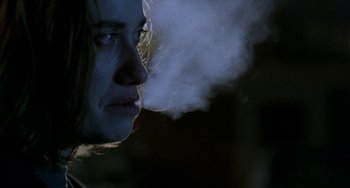 Movie still from “Read My Lips” (2001), directed by Jacques Audiard – A woman is smoking a cigarette in the dark; Close Up shot, Over the shoulder angle
