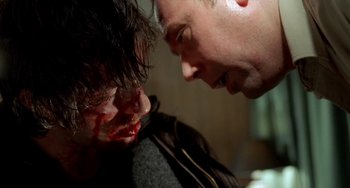 Movie still from “Read My Lips” (2001), directed by Jacques Audiard – A man with blood on his face and another man with blood on his face; Close Up shot, Over the shoulder angle