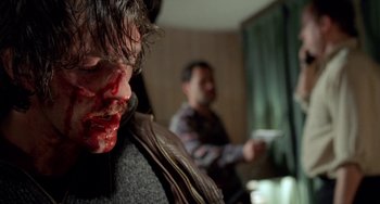 Movie still from “Read My Lips” (2001), directed by Jacques Audiard – A man with blood on his face is holding a knife in front of another man; Close Up shot, Low angle