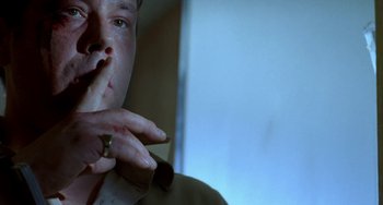 Movie still from “Read My Lips” (2001), directed by Jacques Audiard – A person smoking a cigarette in front of a mirror; Close Up shot, Low angle