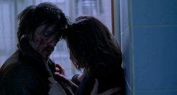 Movie still from “Read My Lips” (2001), directed by Jacques Audiard – A man and a woman embracing each other in front of a window; Close Up shot, Overhead angle