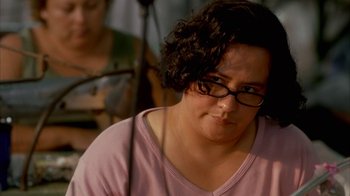 Movie still from “Real Women Have Curves” (2002), directed by Patricia Cardoso – A woman wearing glasses and a pink shirt; Close Up shot, Over the shoulder angle