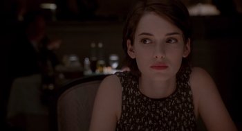 Movie still from “Reality Bites” (1994), directed by Ben Stiller – A woman sitting in a chair looking at the camera; Close Up shot, Over the shoulder angle