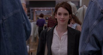 Movie still from “Reality Bites” (1994), directed by Ben Stiller – A woman in a suit and white shirt in a store; Medium shot, Over the shoulder angle