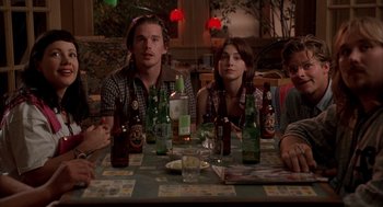 Movie still from “Reality Bites” (1994), directed by Ben Stiller – A group of people sitting at a table with drinks; Medium shot, High angle