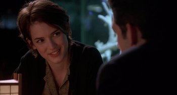 Movie still from “Reality Bites” (1994), directed by Ben Stiller – A woman sitting next to a man at a table; Close Up shot, Over the shoulder angle