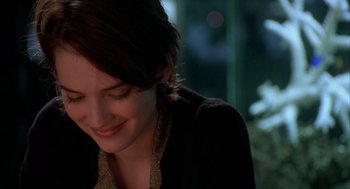 Movie still from “Reality Bites” (1994), directed by Ben Stiller – A person with short brown hair smiling; Close Up shot, Over the shoulder angle