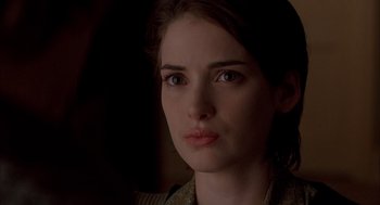 Movie still from “Reality Bites” (1994), directed by Ben Stiller – A woman's face in the dark; Close Up shot, Over the shoulder angle