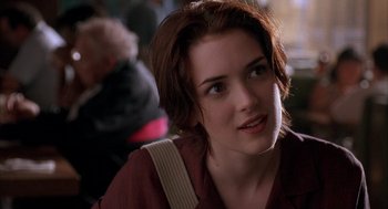 Movie still from “Reality Bites” (1994), directed by Ben Stiller – A person sitting down looking at something; Close Up shot, Over the shoulder angle