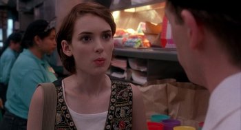 Movie still from “Reality Bites” (1994), directed by Ben Stiller – A young woman sitting in front of a man in front of a refrigerator; Close Up shot, Over the shoulder angle