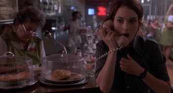 Movie still from “Reality Bites” (1994), directed by Ben Stiller – A woman on the phone at a restaurant; Medium shot, High angle