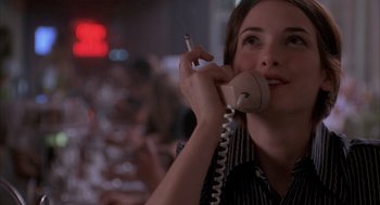Movie still from “Reality Bites” (1994), directed by Ben Stiller – A woman talking on a phone while holding a cigarette; Close Up shot, High angle