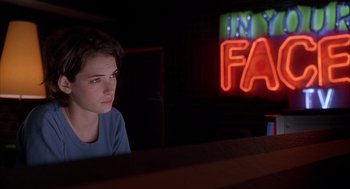 Movie still from “Reality Bites” (1994), directed by Ben Stiller – A person sitting in front of a computer monitor in a dark room; Medium shot, Over the shoulder angle