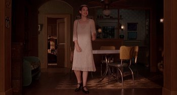 Movie still from “Reality Bites” (1994), directed by Ben Stiller – A woman standing in front of a dining room table; Wide shot, Over the shoulder angle