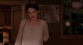 Movie still from “Reality Bites” (1994), directed by Ben Stiller – A woman in a white dress smiling for the camera; Medium shot, Over the shoulder angle