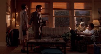 Movie still from “Reality Bites” (1994), directed by Ben Stiller – A man and a woman standing in front of a couch; Wide shot, Over the shoulder angle