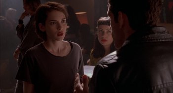 Movie still from “Reality Bites” (1994), directed by Ben Stiller – A group of people standing in a room talking to each other; Close Up shot, Over the shoulder angle