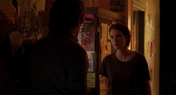 Movie still from “Reality Bites” (1994), directed by Ben Stiller – A woman standing in front of a mirror in a room; Medium shot, Over the shoulder angle