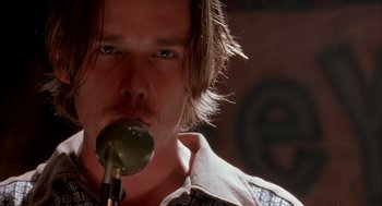 Movie still from “Reality Bites” (1994), directed by Ben Stiller – A person holding a microphone; Close Up shot, Low angle