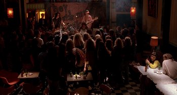 Movie still from “Reality Bites” (1994), directed by Ben Stiller – A group of people sitting around a room with guitars; Wide shot, High angle