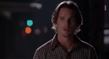 Movie still from “Reality Bites” (1994), directed by Ben Stiller – A man with long brown hair wearing a checkered shirt; Close Up shot, Over the shoulder angle