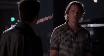 Movie still from “Reality Bites” (1994), directed by Ben Stiller – A man standing next to another man on a city street; Close Up shot, Over the shoulder angle