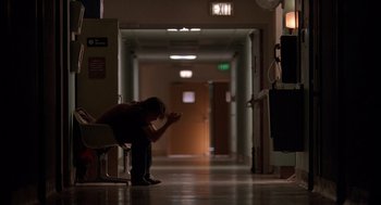 Movie still from “Reality Bites” (1994), directed by Ben Stiller – A person sitting in a room with a cell phone; Wide shot, Low angle