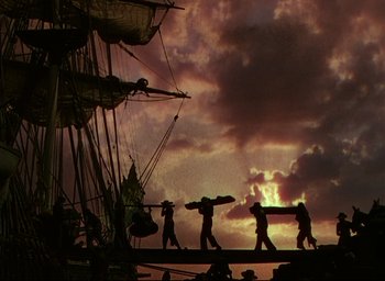 Movie still from “Reap the Wild Wind” (1942), directed by Cecil B. DeMille – A group of men walking across a dock; Wide shot, Low angle