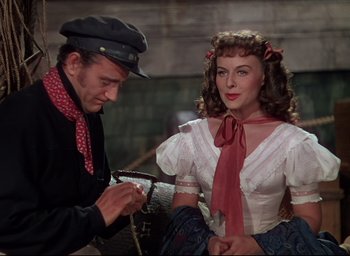 Movie still from “Reap the Wild Wind” (1942), directed by Cecil B. DeMille – A man and a woman are standing next to each other; Medium shot, Over the shoulder angle