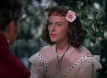 Movie still from “Reap the Wild Wind” (1942), directed by Cecil B. DeMille – A woman with a flower in her hair and wearing a pink dress; Close Up shot, Over the shoulder angle
