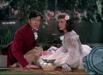 Movie still from “Reap the Wild Wind” (1942), directed by Cecil B. DeMille – A man and a woman sitting next to each other on the ground; Medium shot, High angle